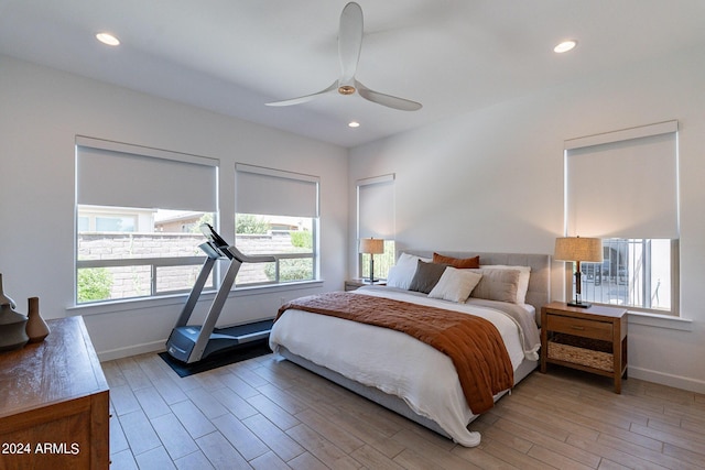 bedroom featuring multiple windows, light hardwood / wood-style flooring, and ceiling fan