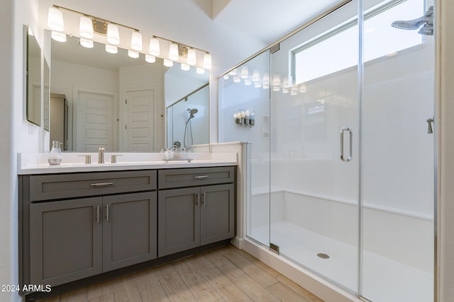 bathroom featuring hardwood / wood-style flooring, vanity, and a shower with shower door