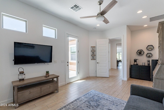 living room with ceiling fan and light hardwood / wood-style flooring