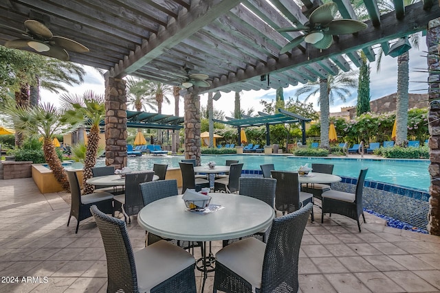 view of patio featuring a community pool and a pergola