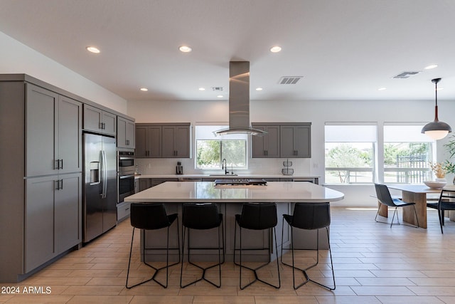 kitchen featuring gray cabinets, appliances with stainless steel finishes, pendant lighting, tasteful backsplash, and sink