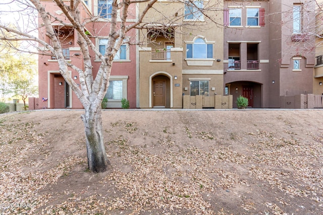 townhome / multi-family property with a fenced front yard and stucco siding