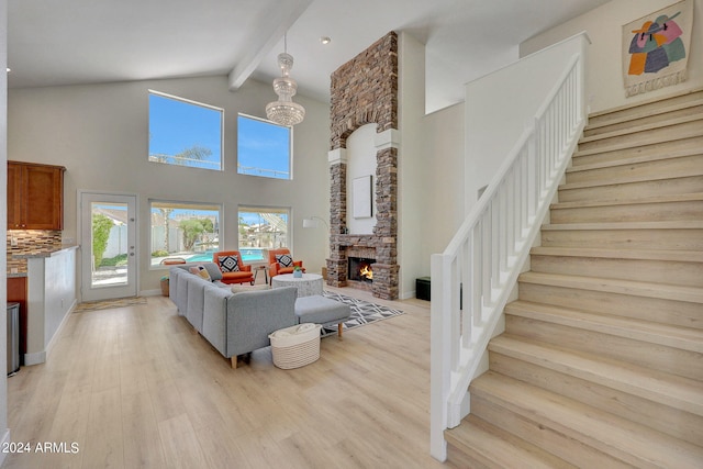 living room with a fireplace, high vaulted ceiling, beam ceiling, and light hardwood / wood-style floors