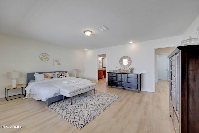 bedroom with light hardwood / wood-style flooring and ensuite bath