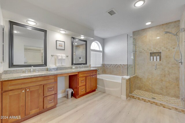 bathroom with vanity, hardwood / wood-style flooring, and plus walk in shower