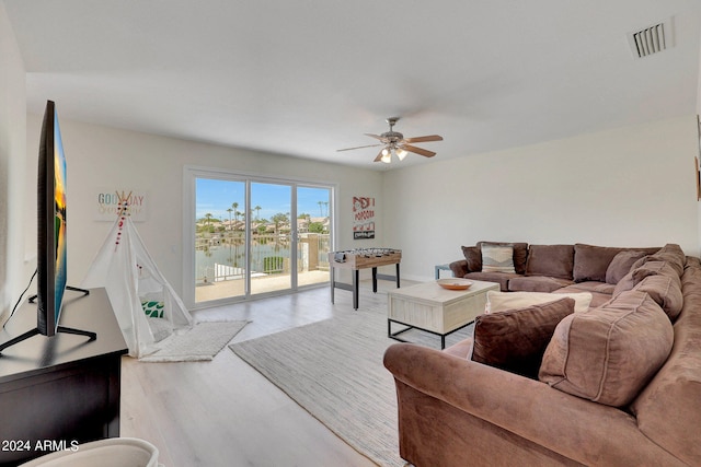 living room featuring a water view, ceiling fan, and wood-type flooring