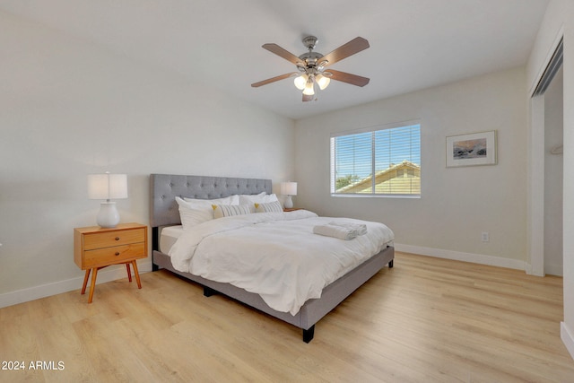 bedroom featuring light wood-type flooring, ceiling fan, and a closet