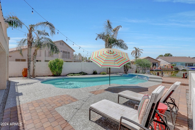 view of swimming pool featuring a patio area, pool water feature, and a water view