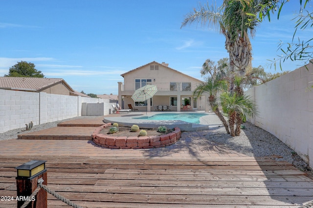 wooden deck featuring a fenced in pool and a patio area