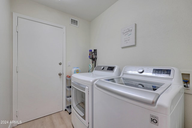 laundry room featuring light hardwood / wood-style floors and separate washer and dryer