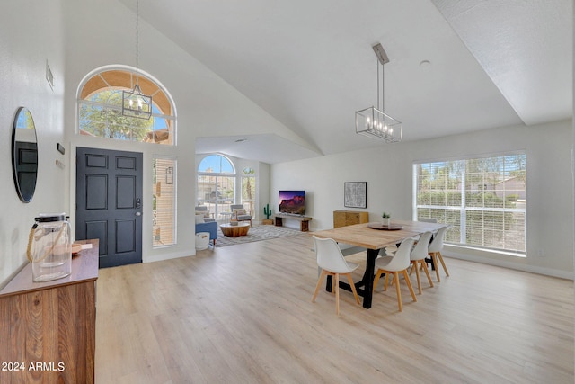 dining room with high vaulted ceiling, a chandelier, and light hardwood / wood-style floors