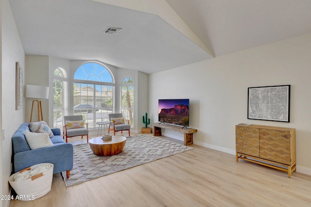 living room with vaulted ceiling and light hardwood / wood-style flooring