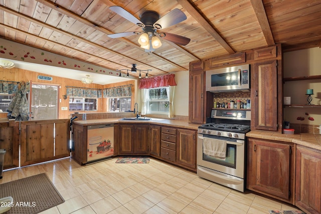 kitchen featuring sink, ceiling fan, stainless steel appliances, wooden ceiling, and beamed ceiling