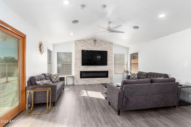 living room featuring a fireplace, ceiling fan, hardwood / wood-style floors, and vaulted ceiling