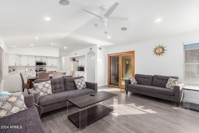 living room featuring ceiling fan, light hardwood / wood-style floors, lofted ceiling, and sink