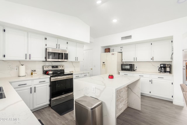 kitchen featuring appliances with stainless steel finishes, light hardwood / wood-style floors, white cabinetry, and a kitchen island