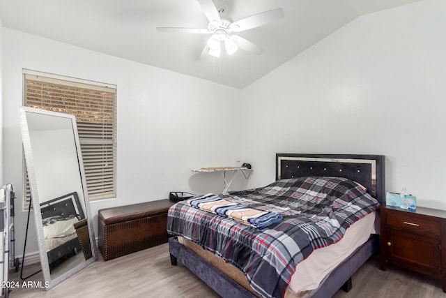 bedroom featuring ceiling fan, light hardwood / wood-style floors, and vaulted ceiling