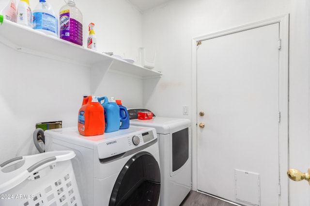 clothes washing area featuring washer and dryer and hardwood / wood-style flooring