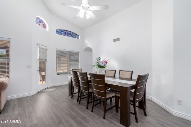 dining space featuring a wealth of natural light, hardwood / wood-style floors, ceiling fan, and high vaulted ceiling