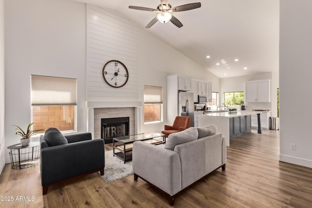 1777 W Redfield Rd, Gilbert, AZ 85233 - living room featuring recessed lighting, ceiling fan, a tile fireplace, high vaulted ceiling, and wood-type flooring
