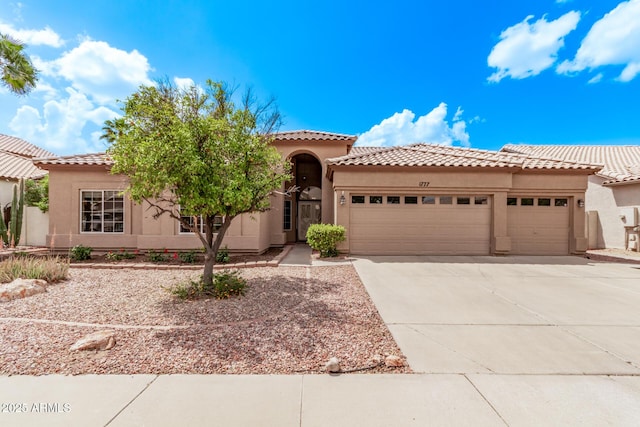 1777 W Redfield Rd, Gilbert, AZ 85233 - mediterranean / spanish-style house with stucco siding, an attached garage, a tiled roof, and concrete driveway