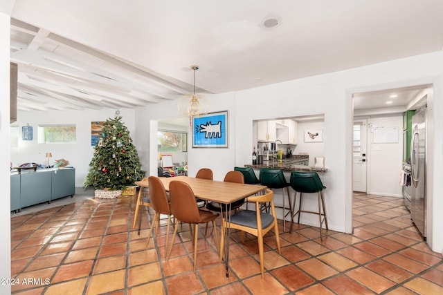 dining area featuring beam ceiling and tile patterned flooring