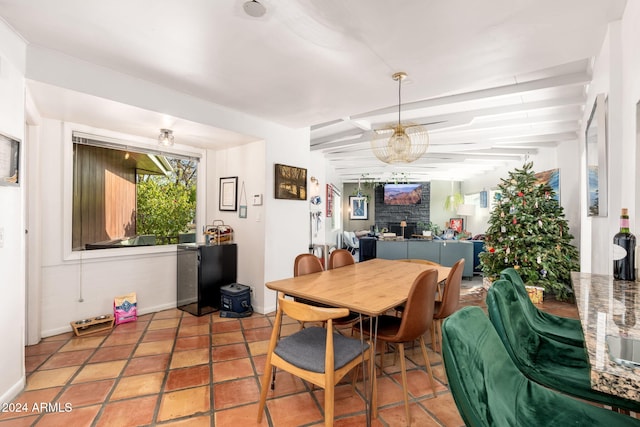 tiled dining area featuring beamed ceiling