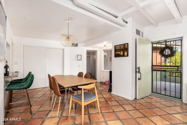 tiled dining space with beam ceiling and a notable chandelier