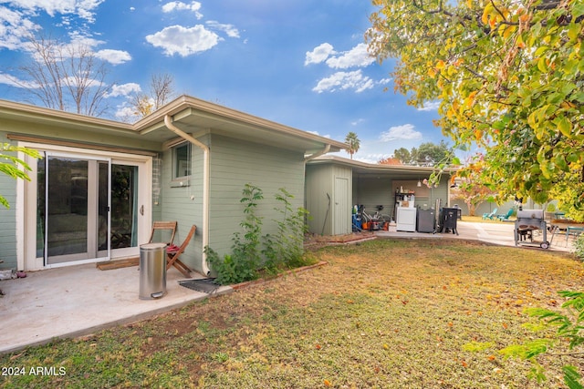 rear view of property with a lawn and a patio