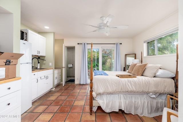 tiled bedroom featuring multiple windows, ceiling fan, sink, and white refrigerator