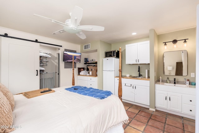 bedroom with ceiling fan, white refrigerator, a barn door, and sink