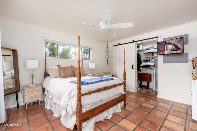 bedroom featuring tile patterned flooring, ceiling fan, a barn door, and a closet