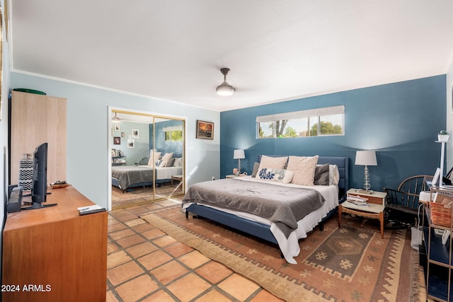 bedroom featuring tile patterned flooring, ceiling fan, and a closet