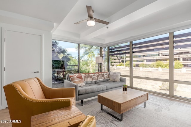 sunroom with a ceiling fan and beamed ceiling