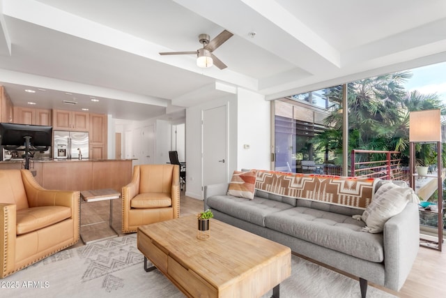 living room featuring ceiling fan and a wall of windows