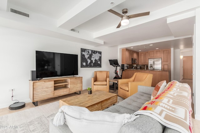 living room featuring baseboards, visible vents, and ceiling fan