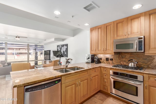 kitchen with a peninsula, a sink, visible vents, open floor plan, and appliances with stainless steel finishes