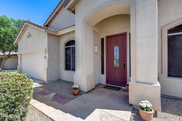 6742 W El Cortez Pl, Peoria, AZ 85383 - view of exterior entry with stucco siding and a garage