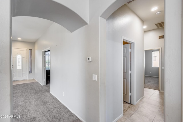 6742 W El Cortez Pl, Peoria, AZ 85383 - hall with arched walkways, light colored carpet, baseboards, light tile patterned floors, and recessed lighting