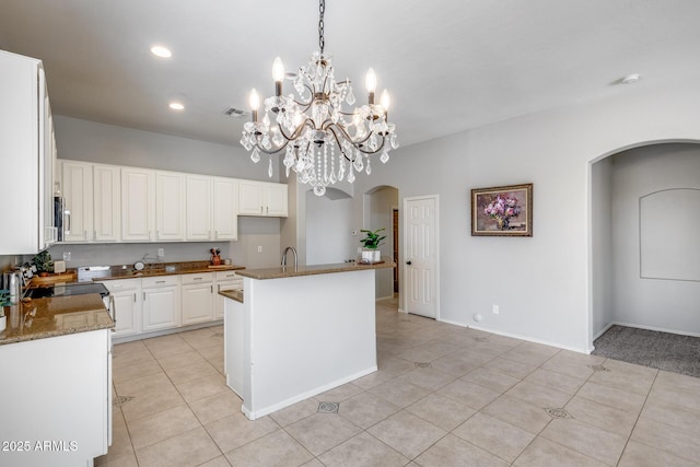 6742 W El Cortez Pl, Peoria, AZ 85383 - kitchen with arched walkways, light tile patterned floors, white cabinetry, and recessed lighting