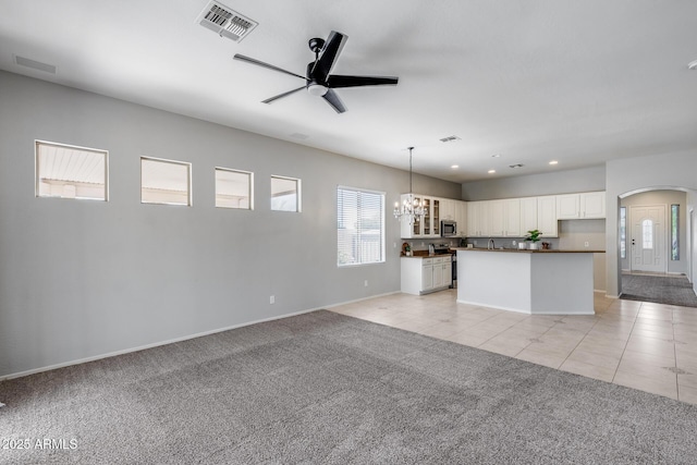 6742 W El Cortez Pl, Peoria, AZ 85383 - kitchen featuring arched walkways, ceiling fan, stainless steel appliances, light carpet, and dark countertops