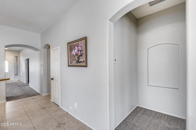 6742 W El Cortez Pl, Peoria, AZ 85383 - hall featuring light colored carpet, baseboards, arched walkways, and light tile patterned flooring
