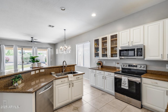 6742 W El Cortez Pl, Peoria, AZ 85383 - kitchen with stainless steel appliances, a sink, light tile patterned flooring, glass insert cabinets, and white cabinetry