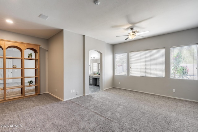 6742 W El Cortez Pl, Peoria, AZ 85383 - carpeted empty room with arched walkways, ceiling fan, baseboards, and a smoke detector