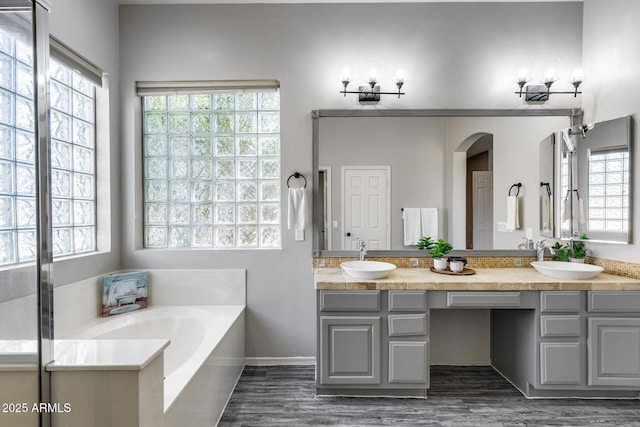 6742 W El Cortez Pl, Peoria, AZ 85383 - full bathroom with double vanity, a bath, healthy amount of natural light, and wood finished floors