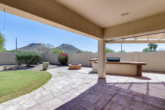 6742 W El Cortez Pl, Peoria, AZ 85383 - fenced backyard featuring a patio, a mountain view, and an outdoor fire pit
