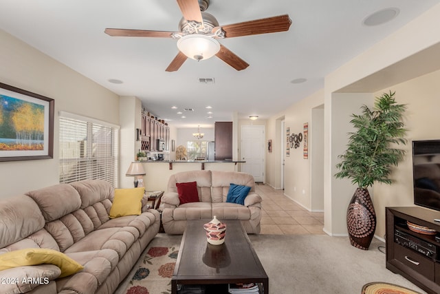 living room featuring light tile patterned floors and ceiling fan with notable chandelier