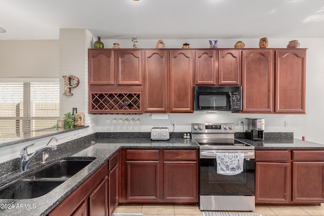 kitchen featuring dark stone countertops, sink, light tile patterned flooring, and stainless steel range with electric stovetop