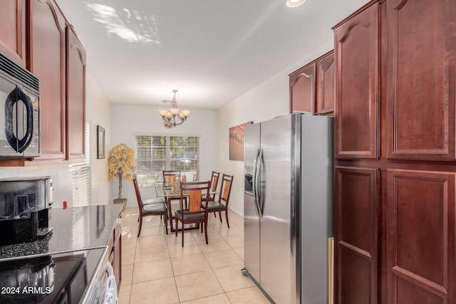 kitchen with hanging light fixtures, stainless steel fridge, stove, a chandelier, and light tile patterned flooring