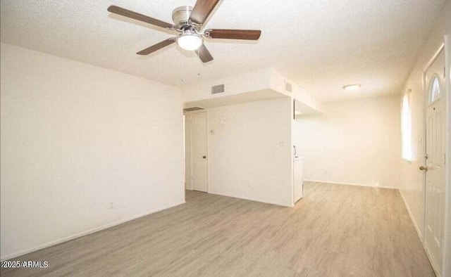 spare room with ceiling fan, a textured ceiling, visible vents, and wood finished floors